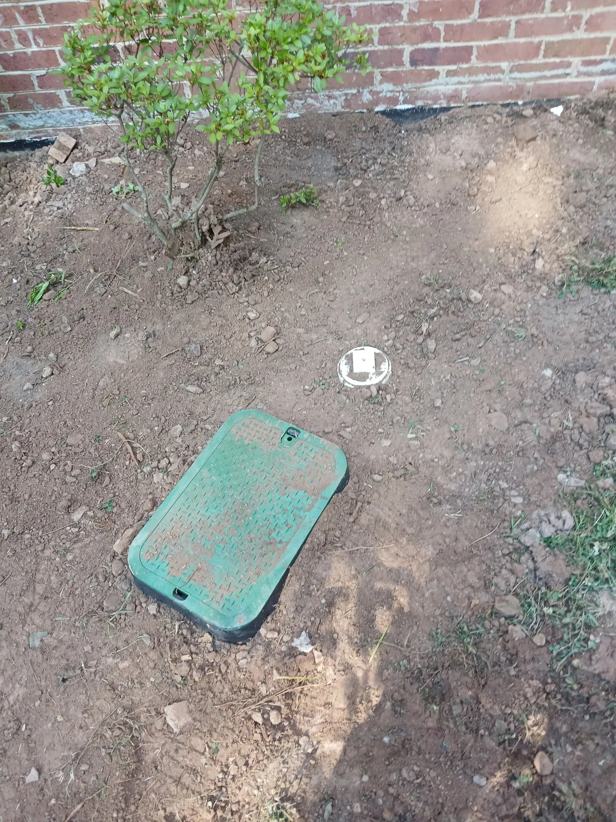 Water meter box lid and cleanout at grade after an underground line repair, by Thomas Plumbing & Construction